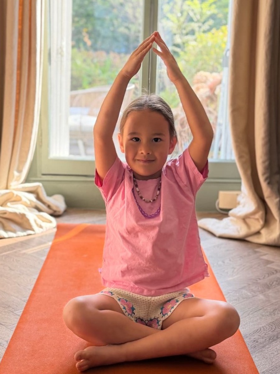 Children practicing yoga poses in a bright, playful class